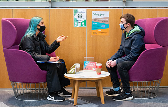 A  University student giving chatting with another student