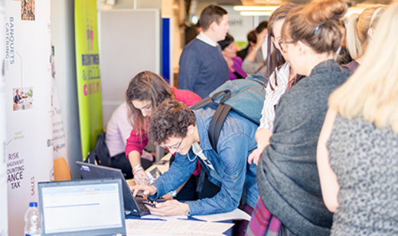 Students using a laptop at a busy recruitment fair, 性用社 campus, Edinburgh