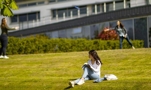 Students playing frisbee on the grass outside  University, Edinburgh