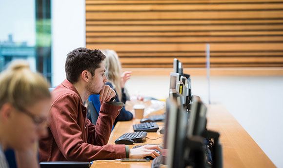 Row of  University students working on desktop computers
