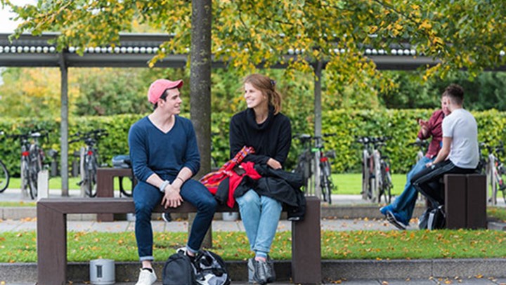  students chatting and smiling on a bench outside, Edinburgh