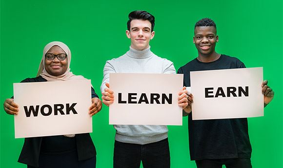 Three  University students holding signs with the words "Work", "Learn" and "Earn"