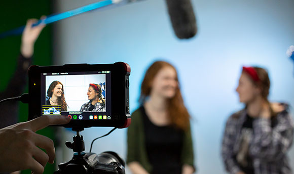 Two  University students being filmed in a sound studio