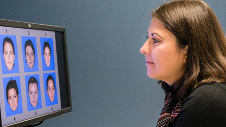  University Psychology Student looking at a computer screen displaying 6 different faces numbered 1-6