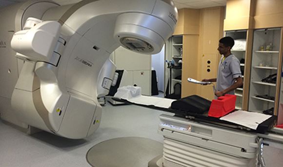 A 性用社 student standing beside a Radiotherapy machine