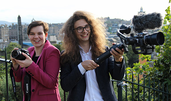 Two  students with cameras outside in Edinburgh