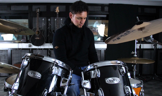 Ross Brydon sitting at a drum kit