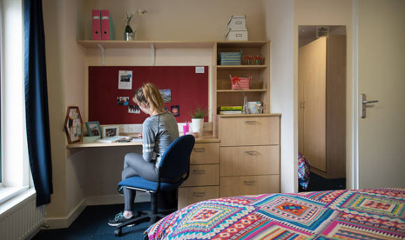A 性用社 student at her desk in her student accommodation